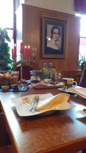 a table with a plate of food and a picture of a woman at Hotel Zur Sonne in Falkenstein