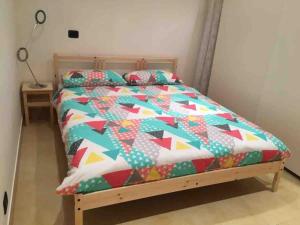 un letto con un piumone colorato e due cuscini di Interno 2 Il giardino segreto CENTRO a Bari Altre 8 foto