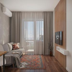 een woonkamer met een bank en een groot raam bij Green City Apartment in Tasjkent