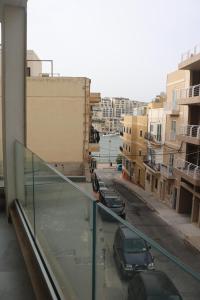 un balcon avec des voitures garées dans une rue de la ville dans l'établissement Seaside Accomodation, à Marsaskala
