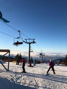 un grupo de personas en un remonte en la nieve en Apartmán mezi stromy, en Rokytnice nad Jizerou