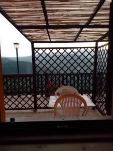 a screened in porch with two chairs and a table at Agriturismo Becerca Vegan in Serra San Quirico