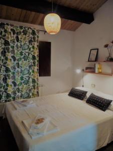 a bedroom with a large white bed with a curtain at Agriturismo Becerca Vegan in Serra San Quirico
