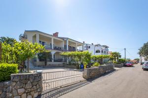 a large white house with a stone wall at Apartment Ana in Vantačići