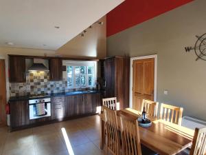 a kitchen with a wooden table and a dining room at 11 An Seanachai Holiday Homes in Dungarvan +10 photos