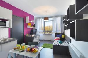 a living room with a kitchen with a table and a room with at Résidence Nemea Villeneuve Métropole in Villeneuve d'Ascq