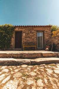 a stone building with a bench in front of it at Moinho d'Antoninha in Leomil