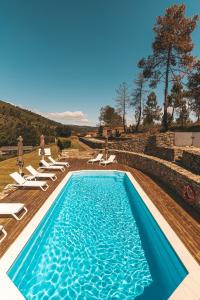 a swimming pool with chaise lounge chairs and a swimming pool at Moinho d'Antoninha in Leomil