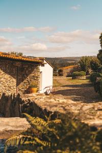 a stone house with a bench in front of it at Moinho d'Antoninha in Leomil