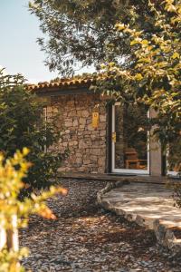 ein Steinhaus mit einer Tür und einem Stuhl in der Unterkunft Moinho d'Antoninha in Leomil