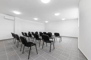 Hérics Apartman في تيهاني: صف من الكراسي في غرفة بجدران بيضاء