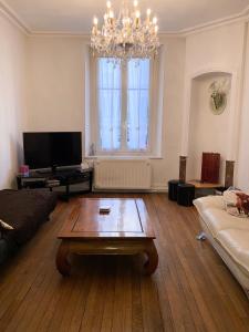 a living room with a coffee table and a chandelier at Le Campus Victoria I - Train Station & Isabey St - 70m2 in Nancy