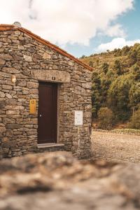 ein Steingebäude mit einer Seitentür in der Unterkunft Moinho d'Antoninha in Leomil