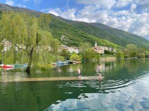 dos personas están de pie en el agua en un lago en Prosecco hills, 1 hour from Venice, swimming pool, ground floor, en Miane