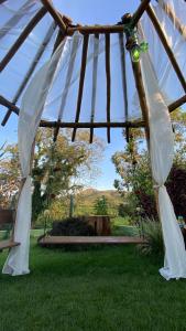 um gazebo com um baloiço num quintal em Pousada Vale do Chapéu em Capitólio