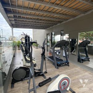 un gimnasio con cintas de correr y elípticas en un edificio en VVC Hotel's en Villavicencio