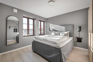 a bedroom with a large bed and a mirror at Frogner House - Pedersgata in Stavanger