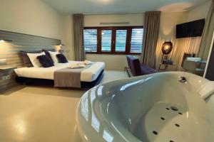 a bedroom with a bed and a tub in a room at Boshotel Overberg in Overberg