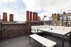 a patio with a table and chairs on a roof at Hausd - Leicester Square in London