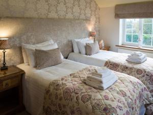 a bedroom with two beds with towels on them at The Blackamoor Inn in Ripon