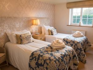 a hotel room with two beds with towels on them at The Blackamoor Inn in Ripon