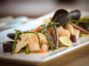 un plato de comida con camarones y verduras en una mesa en The Blackamoor Inn, en Ripon