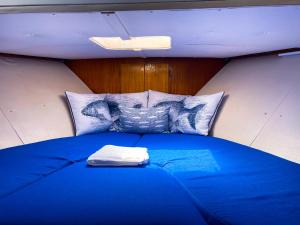 a large blue bed in a room with pillows at Stay in a Yacht - Algarve in Albufeira
