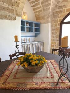 una mesa con un tazón de flores encima en Tenuta Afra en Squinzano