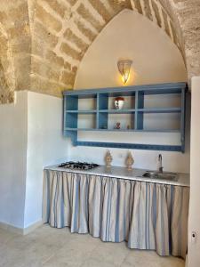 uma cozinha com um balcão com um lavatório e um fogão em Tenuta Afra em Squinzano