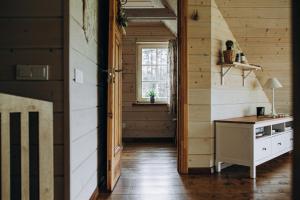 a kitchen with wooden walls and a table and a window at "Gaujmale" sauna house in nature in Laukbeitini +64 photos