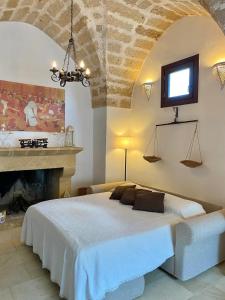 a bedroom with a large bed and a fireplace at Tenuta Afra in Squinzano