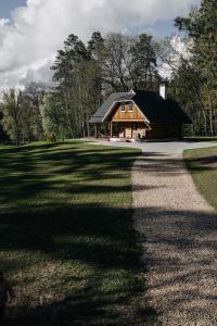 "Gaujmale" sauna house in nature في Laukbeitini: كابينة خشب فيها مسار يؤدي إليها