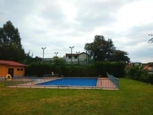 a swimming pool in a yard with a grass field at Apartamento Bárcenas 3 in Llanes