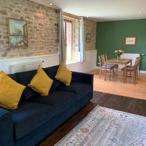 sala de estar con sofá azul y mesa en Les Rouges Terres Gites - La Vieille Grange en Saint-Amand