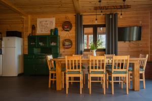 ein Esszimmer mit einem Holztisch und Stühlen in der Unterkunft Domek w Biebrzańskim Eldorado in Dolistowo Stare