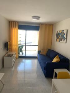 a living room with a blue couch and a window at Turquesa beach in Calpe