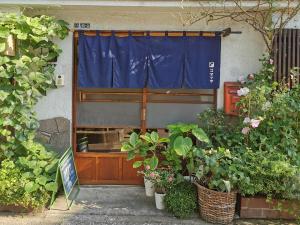 a window with a blue curtain and some plants at Komatsuya in Tokyo