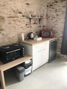 a kitchen with a counter top and a microwave at Maison De Vacances A Brambuan in Josselin