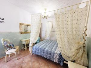 een slaapkamer met een bed met een gordijn en een stoel bij Bellavista Versilia in Pietrasanta