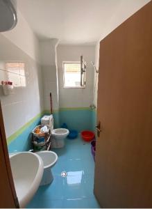 a bathroom with two toilets and a blue floor at Rori’s Apartment Qerret in Golem