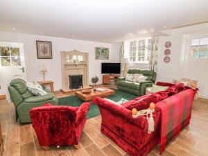 a living room with red furniture and a fireplace at Chestnut Cottage in Sheffield