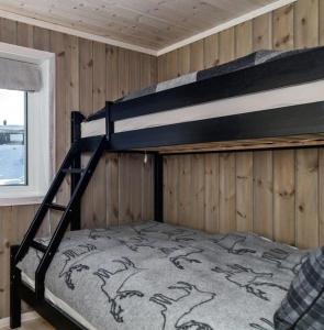 um beliche num quarto com paredes de madeira em Beautiful cabin close to activities in Trysil, Trysilfjellet, with Sauna, 4 Bedrooms, 2 bathrooms and Wifi em Trysil