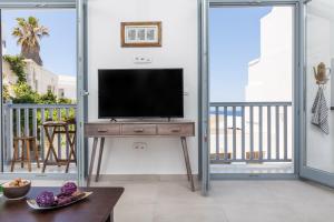 a living room with a television on a table at Alkara Middle in Naxos Chora