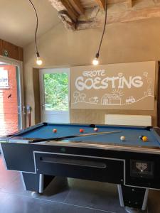 a pool table in a room with a sign at Grote Goesting holiday house in Wevelgem