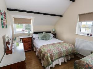 a bedroom with a large bed and two windows at Y Cartws in Llandysul