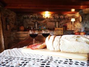 a table with two glasses of red wine and bread at Casa do Pontelhão Serra d'Arga in Arga de Cima +46 photos