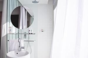 a white bathroom with a sink and a mirror at Casa Lit Barcelona by Ona Hotels in Barcelona