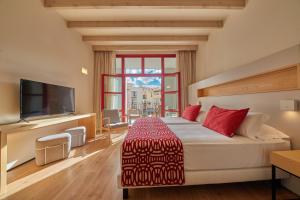 a hotel room with a large bed and a television at Fil Suites in Palma de Mallorca