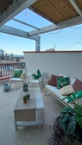 a patio with couches and a table and a view of the ocean at Casa Vacanze Gloria in Castellammare del Golfo