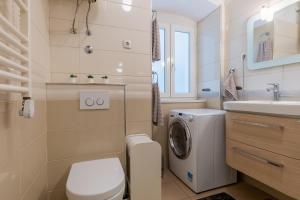 ein Badezimmer mit einer Waschmaschine und einem Waschbecken in der Unterkunft Apartman Kortil in Rijeka